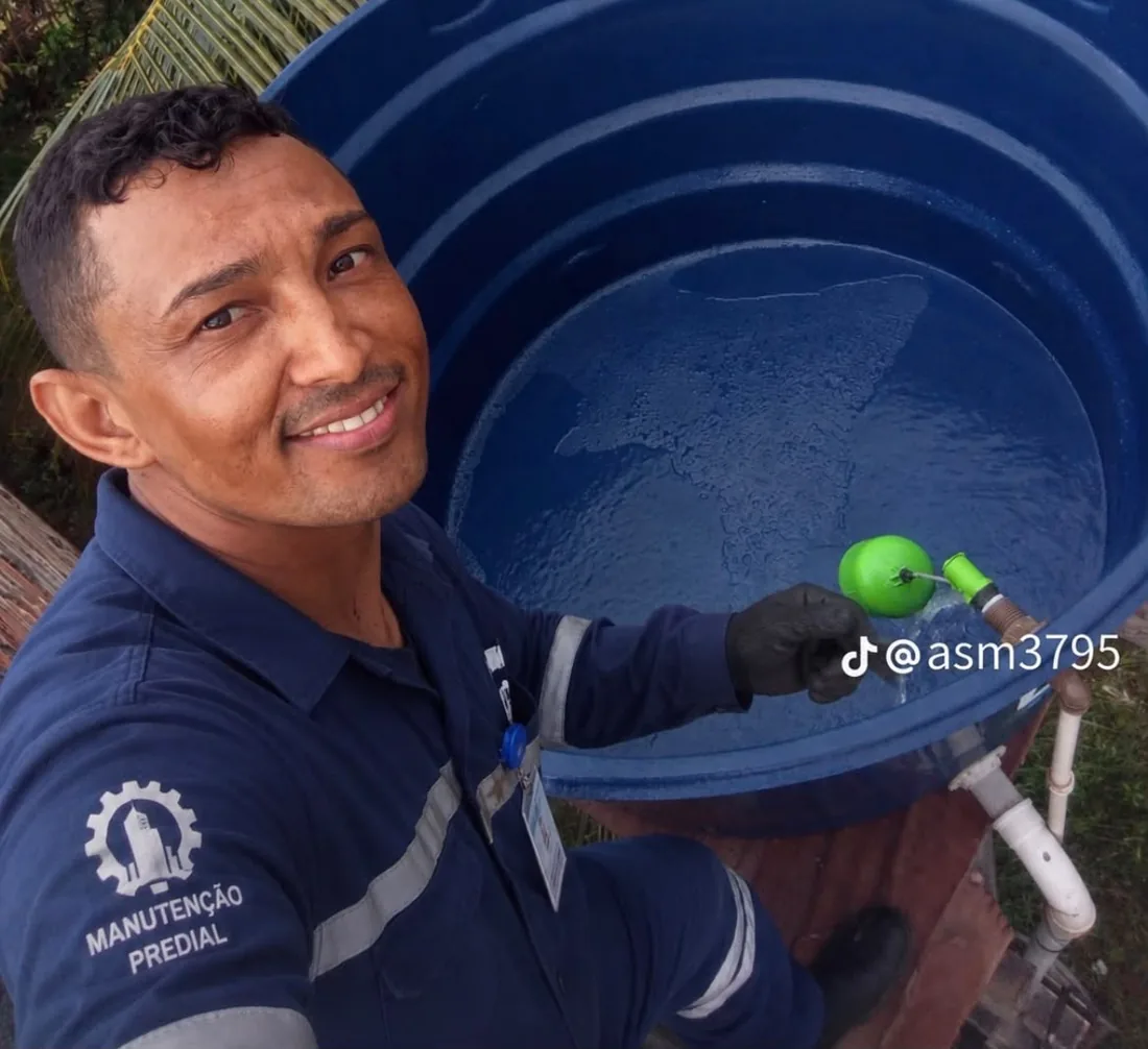 Técnico da ASM realizando manutenção em caixa d'água